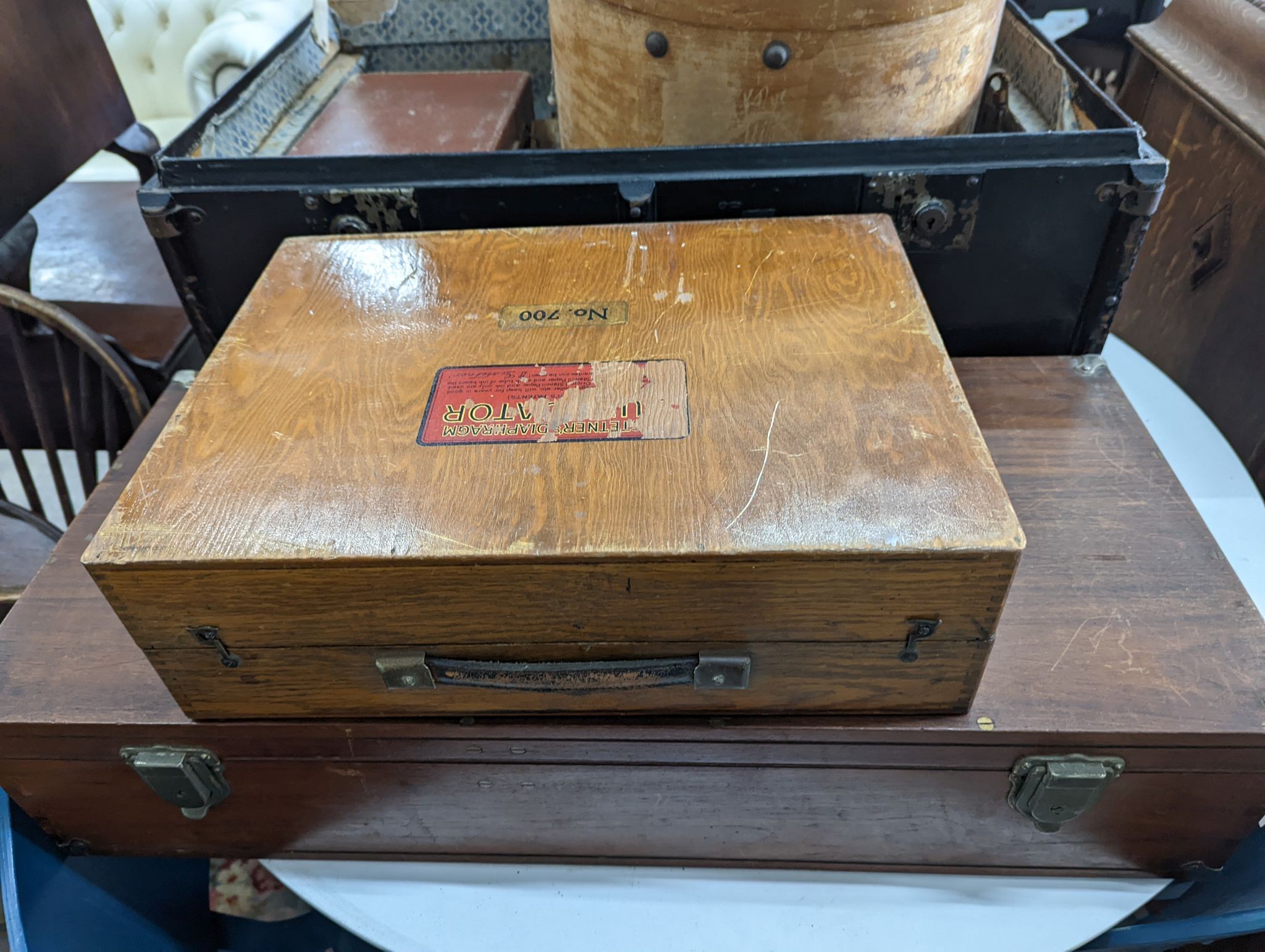 A vintage iron bound wooden travelling trunk, a suitcase, hat box, an artist travel case, and green baize compartments and a small attache case (6)